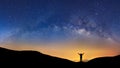 Panorama landscape with milky way, Night sky with stars and silhouette of a standing sporty man with raised up arms on high mount Royalty Free Stock Photo