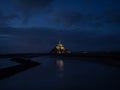 Panorama landscape night view of Mont Saint Michel famous remote isolated island rock castle town in Normandy France Royalty Free Stock Photo