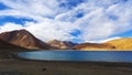 Panorama landscape of Pangong lake with mountain background under winter blue sky.Pangong tso with cloudy sky.