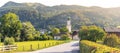 landscape with road and church tower in the village of Sankt Gilgen, Zwolferhorn mountains in background, Alps, Austria Royalty Free Stock Photo