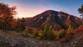 Panorama landscape at sunset with autumn forest, rocks, sun and mountain Royalty Free Stock Photo