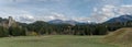 Panorama landscape view of green pastures and forest in fall colors with snow-capped mountains behind in the Alps of Switzerland Royalty Free Stock Photo