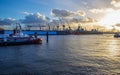 Panorama: line of cranes and windmills and sunbeams through the clouds in harbor of Hamburg.