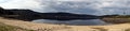 Panorama of Lipno water reservoir with canoe, sandy beach and hills Royalty Free Stock Photo