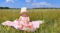 Panorama, little girl in a hat sitting on green field Royalty Free Stock Photo