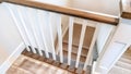 Panorama Looking down on U shaped indoor staircase with white baluster and brown handrail