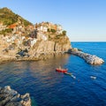 Panorama of Manarola in Cinque Terre, La Spezia. Colorful buildings near the ligurian sea. View on boats moored in marina with Royalty Free Stock Photo