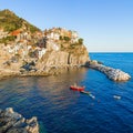 Panorama of Manarola in Cinque Terre, La Spezia. Colorful buildings near the ligurian sea. View on boats moored in marina with