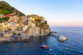 Panorama of Manarola in Cinque Terre, La Spezia. Colorful buildings near the ligurian sea. View on boats moored in marina with Royalty Free Stock Photo