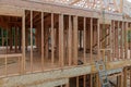 Panorama of condominium building with under construction wooden house with timber framing, truss, joist, beam close-up