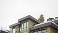 Panorama Modern home exterior with stone wall and flat roof against white sky in winter