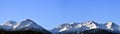 Panorama of mountain peaks with freshly fallen white snow.