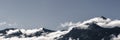 Panorama of mountain range with fog and billowing clouds