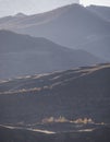 Panorama of mountain slopes and peaks on an autumn morning with bright sunlight backlight Royalty Free Stock Photo