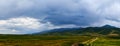 Panorama of a mountain valley in the summer, cloudy sky. Fairytale sunset over the mountain peaks, amazing nature, summer in the m Royalty Free Stock Photo