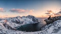 Panorama of Mountaineer sitting on rock on peak mountain of arctic coastline at sunset Royalty Free Stock Photo