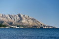 Panorama of mountains with green trees by the sea against the background of a bright blue sky Royalty Free Stock Photo