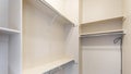 Panorama Narrow windowless walk-in closet with shelves and metal rods