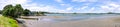 Panorama of Ngunguru Harbour river estuary at low tide - waterfront with anchored motor boat in Northland, New Zealand, NZ