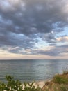 Panorama of Odessa Black Sea coast above heavy gray clouds reflected on clear water surface.