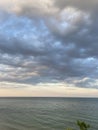 Panorama of Odessa Black Sea coast above heavy gray clouds reflected on clear water surface.