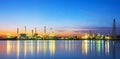 Panorama of oil refinery with reflection, petrochemical plant.Gas refinery beside river.Colorful twilight at sunrise time.