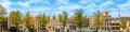 Panorama of the old houses of Amsterdam on the background of the blue sky. Roofs of houses, windows and facades. Panoramic