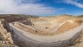 Panorama over quarry, fluxes for the metal industry. Oval mining industrial crater, acid mine drainage in rock Royalty Free Stock Photo