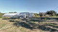 Panoramic view with a plastic greenhouse installed in a wild garden. Organically grown vegetables Royalty Free Stock Photo