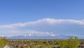 Panorama Panoramic view of rooftops and lush trees under blue sky with puffy clouds Royalty Free Stock Photo