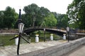 Panorama of the park. View of the bridge over the pond and beautiful lanterns. Metal lanterns with figures of musicians.