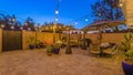 Panorama Patio dining and seating area inside the stone fence and wooden gate of a home