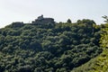 Panorama with peaks overgrown with old green forest and a view of the Glozhene Monastery in the distance in the Balkan Mountains Royalty Free Stock Photo