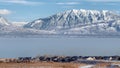 Panorama Picturesque Wasatch Mountains and Utah Lake under cloudy blue sky in winter