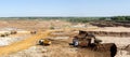 Panorama of the sand pit. Extraction of sand in the quarry. Backhoe loading sand into dump trucks.