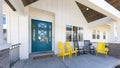 Panorama Porch of a house with blue green door and lounge chairs