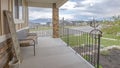 Panorama Porch overlooking yard road homes lake and mountain under cloudy blue sky