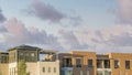 Panorama Puffy clouds at sunset Exterior of the top floors of two complex apartment buildings wi