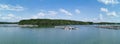 Panorama of raft in sea with small mountain in background and blue sky in sunny day. White cloud reflect with sea surface. Royalty Free Stock Photo