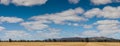 panorama of harvested farm fields with the Grampians mountains rising in the distance on the horizon, rural Victoria,