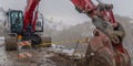 Panorama Red excavator and barricade on a muddy mountain road viewed in winter Royalty Free Stock Photo