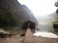 Panorama reflection of old wooden boat house shed alpine mountain lake Obersee Koenigssee Berchtesgaden Bavaria Germany