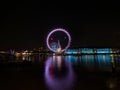 Panorama reflection of tourist ferris wheel Millennium London eye in Thames river at night England Great Britain UK