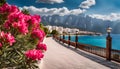 Panorama of the resort with the Sea, wide beach, scarlet oleander bush, wooden fence and lanterns in retro style Royalty Free Stock Photo