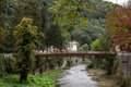 Panorama of the river Cerna in Baile Herculane, with te podul de fonta, or cast iron bridge, a rusty vintage bridge, in the middle Royalty Free Stock Photo