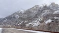 Panorama Road along steep snowy mountain in Provo Canyon with cloudy sky background
