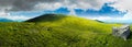 Panorama with rock on the grassy hill in mountains Royalty Free Stock Photo