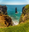 A panorama of a rock stack viewed down a secluded inlet on the Pembrokeshire coast, Wales near Castlemartin Royalty Free Stock Photo