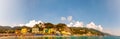 Panorama of rocky marina, clear water of Ligurian Sea, sea ships, beach full of people, waterfront buildings in Monterosso Al Mare Royalty Free Stock Photo