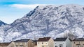 Panorama Row of beautiful homes against a rugged mountain dusted with snow in winter Royalty Free Stock Photo